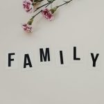 Elegant arrangement of pink flowers and family text on a white background, ideal for family themes.