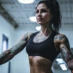 woman wearing black sports bra with tattoos